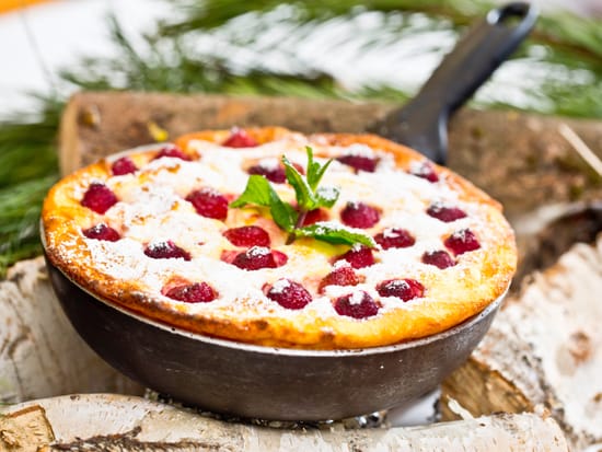 Oven pancake with raspberries and powdered sugar.