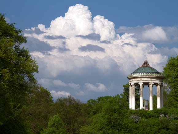 Monopteros in Munich's English Garden with cloudy sky.