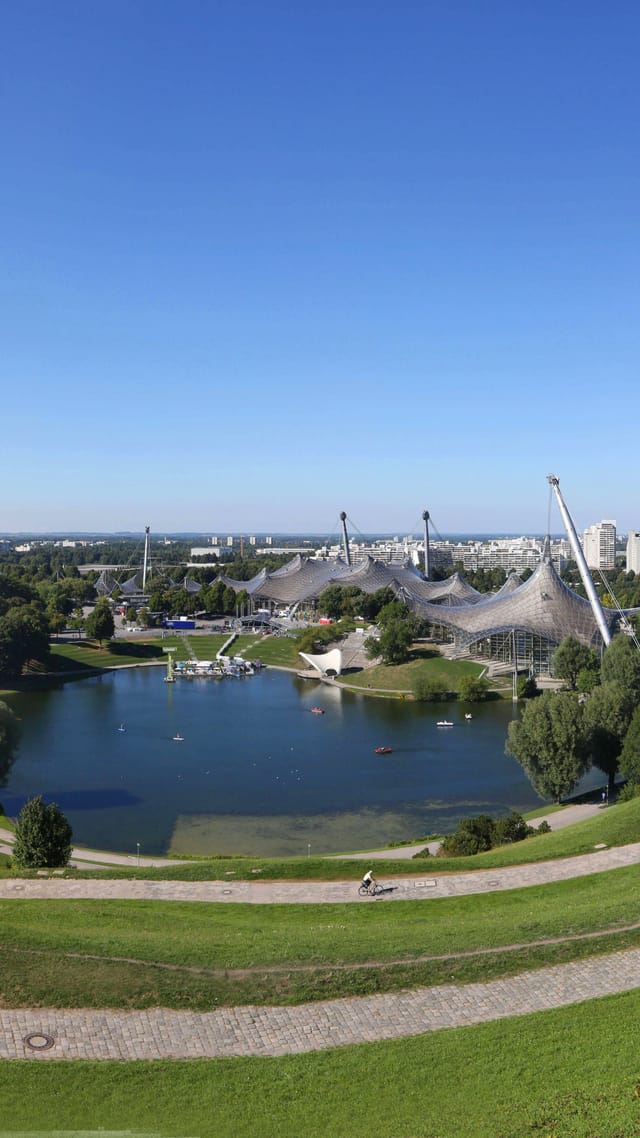 Panoramablick über das Olympiagelände München mit Olympiaturm und Olympiasee.