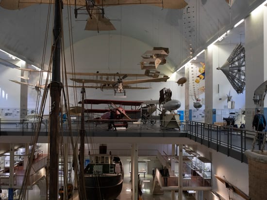 Luftfahrtausstellung im Deutschen Museum München mit historischen Flugzeugen, die von der Decke der weitläufigen Halle hängen.
