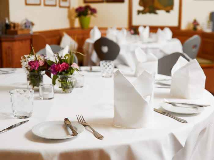 Elegantly set table with fine cutlery and floral accent.