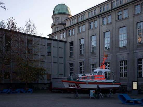 Innenhof des Deutschen Museums München in der Abenddämmerung, mit historischer Backsteinfassade und Ausstellungsobjekten im Hof.