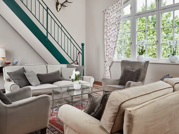 Lobby with gray velvet sofas and armchairs on the 2nd floor in front of the windows.