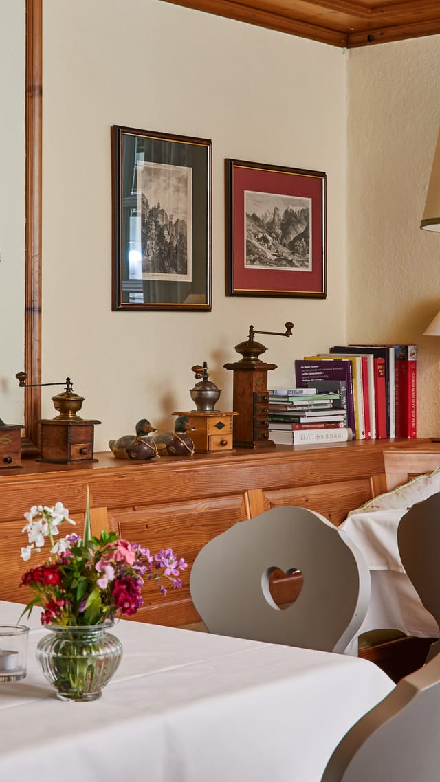 Traditional dining room with tiled stove and set tables.