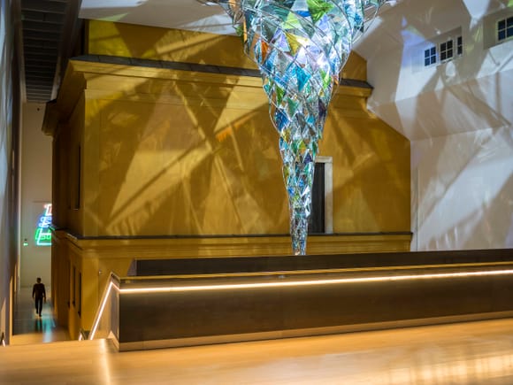 Das "Wirbelwerk" von Olafur Eliasson im Lenbachhaus München, eine spiralförmige Installation aus buntem Glas im goldenen Treppenhaus.