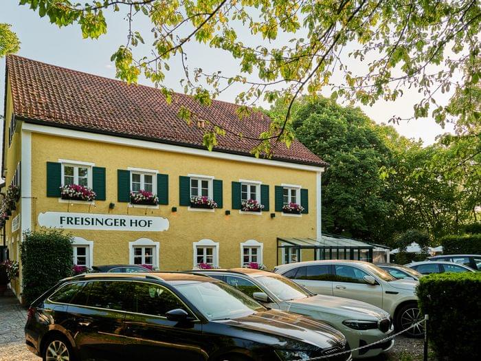 Seitliche Restaurantfassade mit parkenden Autos davor.